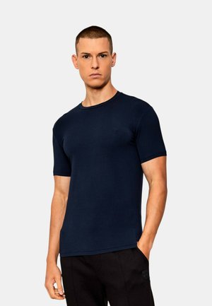 T-shirt a maniche corte blu navy realizzato in cotone morbido, con scollatura rotonda e vestibilità slim, caratterizzato da un branding minimale sul petto.