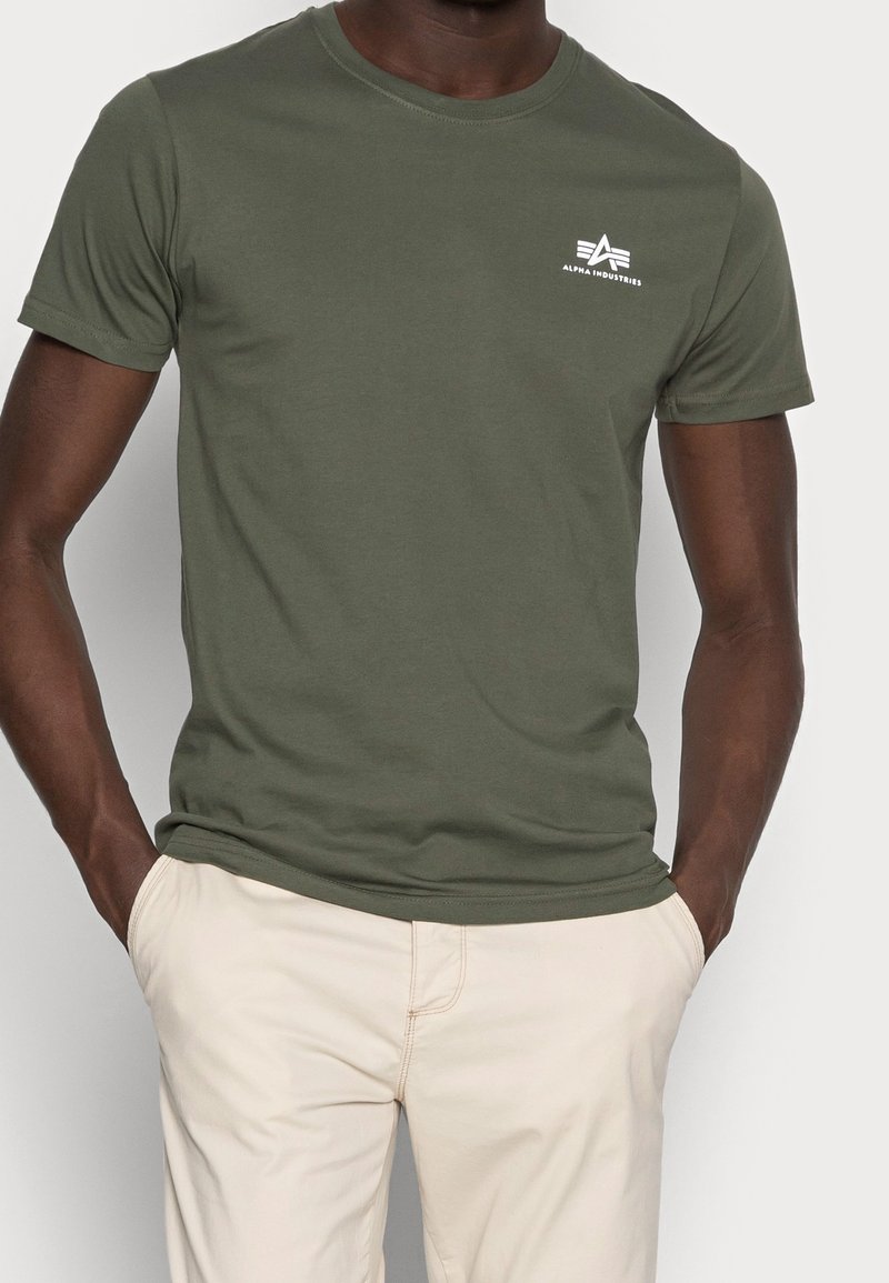 Olive green cotton t-shirt with a round neckline, short sleeves, side seams, and a small white logo on the left chest area.