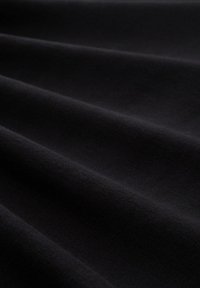 Material textil negru cu o suprafață moale și texturată, prezentând pliuri și ondulații subtile, evidențiind căderea și adâncimea sa.