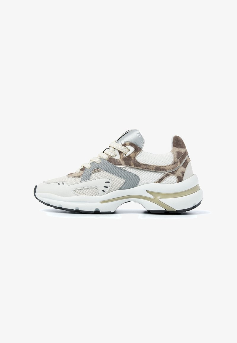 Sport sneaker met een gestructureerde witte mesh bovenkant, lichtbeige en grijze accenten, en een contrasterende zwarte zool. Heeft afgeronde randen en een vetersluiting.