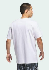 Camiseta de algodón blanca de manga corta y cuello redondo, mostrando la vista trasera. La tela parece suave y tiene un corte relajado.