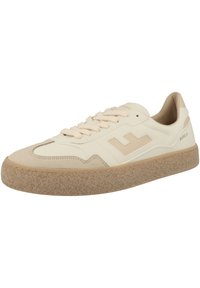 Light beige sneakers with a smooth leather upper and suede accents, featuring a textured rubber sole and thin laces. Simple logo detail on side.