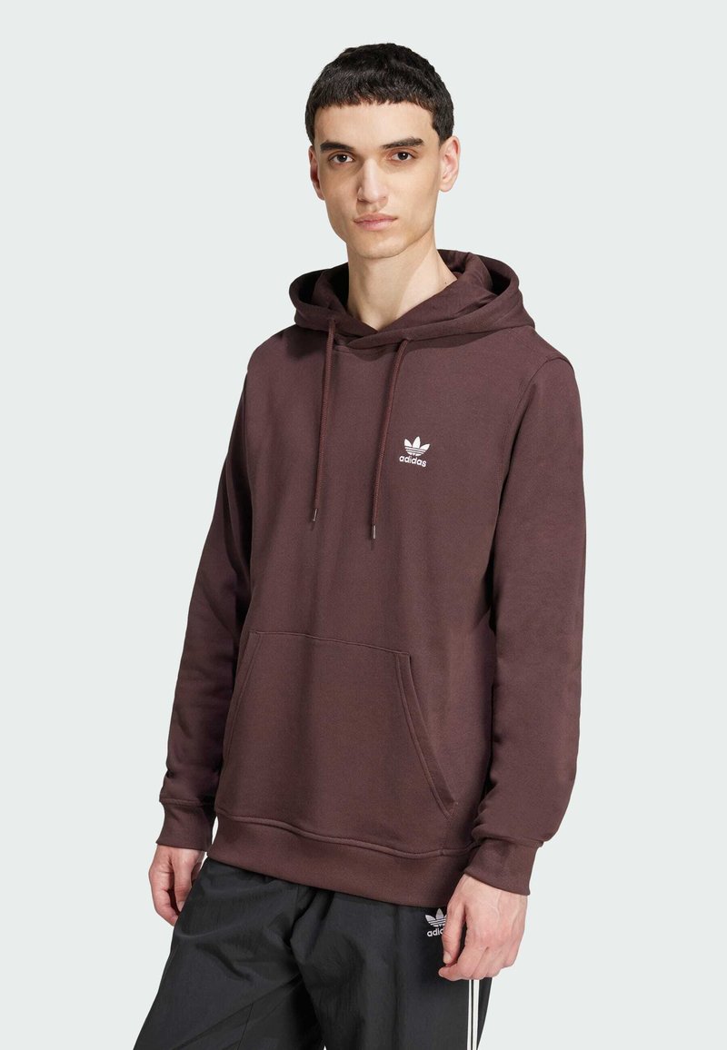 Sweat à capuche en coton marron avec poche kangourou, capuche réglable avec cordon et logo Adidas blanc sur la poitrine.