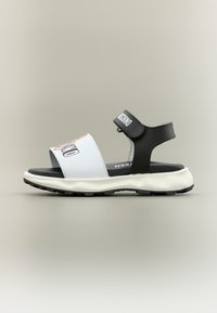 Ανοιχτό μαύρο-άσπρο σανδάλι με ρυθμιζόμενο λουράκι στον αστράγαλο και λογότυπο στη μπροστινή λουρίδα, μαλακή σόλα και υφασμένη εξωτερική σόλα.