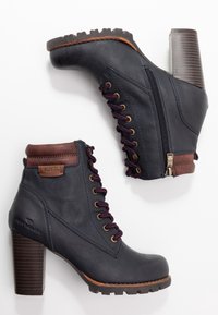 Botas de tobillo de cuero azul oscuro con un acabado texturizado, detalles en marrón, cordones morados, cremallera lateral y tacón de madera grueso.