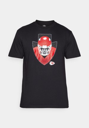 Camiseta de algodón negra con un gráfico de un casco de fútbol americano rojo sobre un fondo de escudo gris, con un pequeño logotipo blanco del equipo en la esquina inferior.