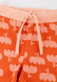 Orange pants with a pink floral pattern, featuring a soft elastic waistband and drawstring. Made from lightweight cotton.