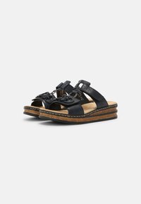 Sandali open-toe in pelle blu navy con suola in sughero e gomma. Presentano cinturini regolabili e hardware decorativo sulla parte superiore.