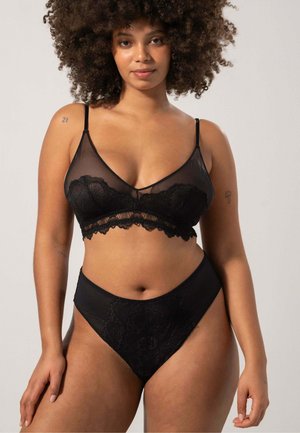 Set di lingerie nero composto da un reggiseno trasparente con ferretto e dettagli in pizzo, abbinato a mutandine a vita alta, entrambi realizzati in materiale morbido e liscio.