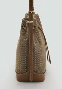Sac seau en toile marron avec motif géométrique, accents en cuir, fermeture à cordon et une sangle ajustable. Texture lisse, forme structurée.