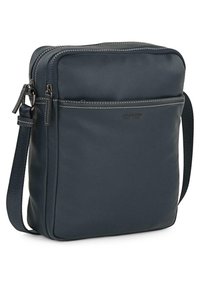 Bolso cruzado de cuero en color navy con dos compartimentos con cremallera, un bolsillo frontal y detalle de costura en contraste. Correa de tela ajustable.