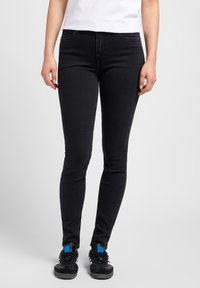 Jean skinny noirs en denim à la texture lisse, avec un design classique à cinq poches et une légère élasticité pour le confort.