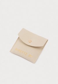 Piccolo pouch in suede beige con chiusura a pressione, forma rettangolare e "GINETTE NY" impresso in lettere dorate sul fronte.