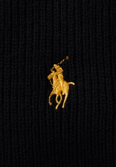 Crni rebrasti materijal s istaknuto izvezenim logotipom polo igrača u zlatnoj boji. Tekstura je pletena, s vidljivim vertikalnim linijama.