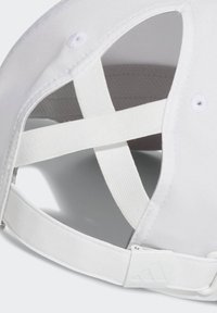 Gorra blanca con interior de malla transpirable, correa ajustable y bandas elásticas cruzadas para un ajuste seguro. Diseñada para ofrecer comodidad y ventilación.