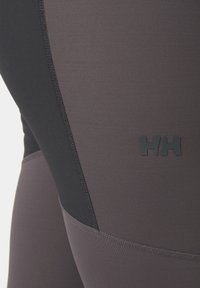 Tight-fitting leggings met een kleurblokontwerp in donkergrijs en paars, gemaakt van een gestructureerde, rekbare stof met een logodetail.