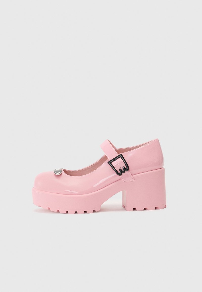 Pink patent leather Mary Jane shoes with a chunky platform, rounded toe, and an adjustable strap featuring a black buckle detail.