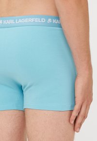 Boxers azul claro hechos de una tela suave, con una cinturilla de logo en contraste que presenta el texto "KARL LAGERFELD".