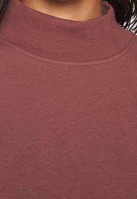 Top a collozzo mauve, texture a coste, design aderente, tessuto morbido, bordi senza cuciture, adatto per stratificazione.