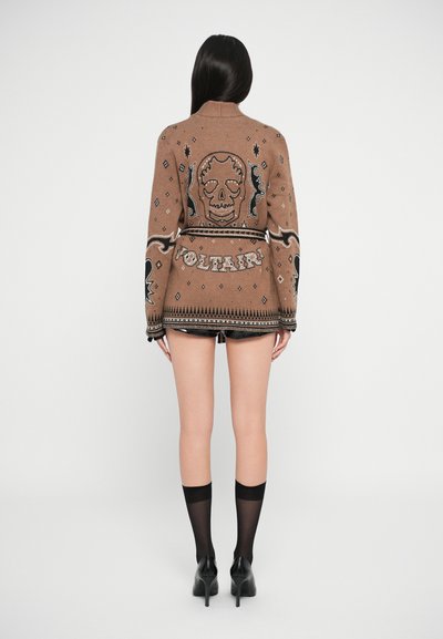 Cardigan marron à motif avec un design de crâne et le texte "Voltair". Comprend des accents noirs, des manches longues et un tissu tricoté doux et texturé.