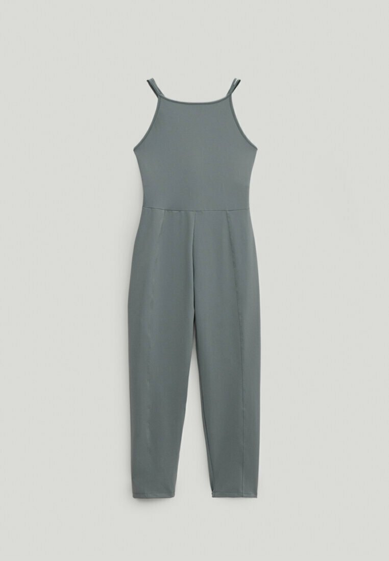 Szary kombinezon na cienkich paskach, z dopasowanym górą i zwężanymi nogawkami. Wykonany z gładkiego materiału, charakteryzujący się minimalną liczbą szwów i prostym wzornictwem.