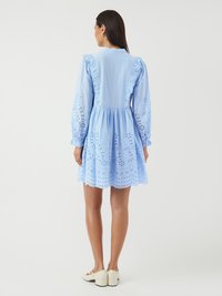 Rochie bleu deschis cu mâneci lungi tip puff, detalii cu volan pe umeri, broderie cu găurele și fustă evazată. Design simplu, până la genunchi.