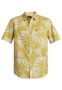 Camicia a maniche corte in cotone giallo con grande motivo a foglie bianche, chiusura con bottoni e taschino singolo sul lato sinistro del petto.