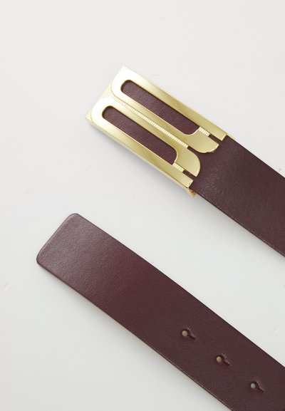 Cinturón de cuero burdeos con una hebilla de metal dorado que presenta recortes alargados y un acabado texturizado. Ajustable con varios agujeros a lo largo de la correa.