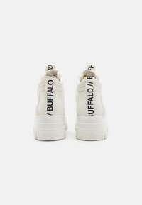 Hvide højtop sneakers med en glat læderstruktur, udstyret med sort "BUZZALO" branding på hælen og en tykk hvid sål.
