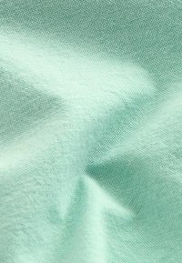 Világos türkiz színű anyag, struktúrált szövettel, sima felülettel és puhán gyűrött redőkkel, amely különböző textil alkalmazásokhoz alkalmas.