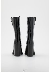 Black patent leather ankle boots with a square toe, chunky heel, and pull tabs on the back. Sleek finish with slight texture.