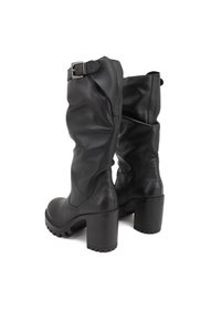 Stivali neri in pelle, alti fino al ginocchio, con un design svasato, dettagli con fibbia sul lato e tacco chunky. Suola in gomma texturizzata per una buona aderenza.
