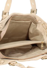 Le sac à main en suédé beige possède un intérieur avec plusieurs compartiments, y compris une poche zippée, avec des finitions en métal doré et une texture douce et lisse.