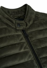 Abrigo acolchado de color verde oscuro con cuello alto, cierre de cremallera y detalles en botón a presión negros. Presenta una textura acolchada y un diseño elegante.