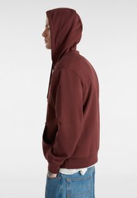 Felpa bordeaux con tasca frontale, cappuccio regolabile con coulisse e polsini e orlo a costine. Tessuto morbido e liscio con una vestibilità comoda.