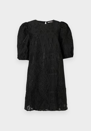 Vestido preto até ao joelho com mangas balão e padrões geométricos intrincados em textura por todo o tecido, colocado contra um fundo simples.