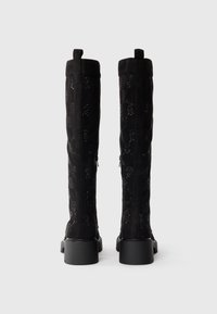 Black knee-high boots with a suede finish, featuring a textured pattern and square heels. Back zippers are visible on the outer sides.