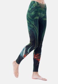 Legging gemaakt van rekbare stof, met een levendig groen bladpatroon en tropische bloemenaccenten, strakke pasvorm en een zachte textuur.