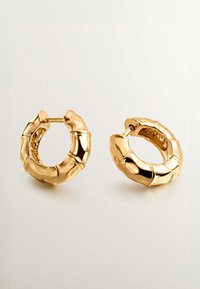 Pendientes de aro dorados con un diseño texturizado parecido al bambú. Forma circular con sutiles detalles y un acabado pulido que realza el interés visual.