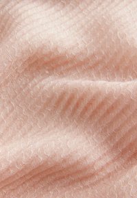 Tissu texturé rose clair avec un motif ondulé, présentant un léger brillant et des détails de tissage délicats. Surface douce et lisse.