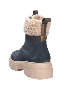 Stivaletti alla caviglia blu navy con risvolto in ecopelliccia crema, esterno in pelle texturizzata e suola chunky beige. Presentano un passante per una facile calzata.