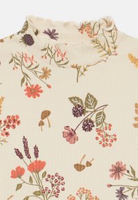 Top in tessuto crema a coste con colletto svasato, caratterizzato da un motivo floreale multicolore, con tocchi di rosa, viola e verde.