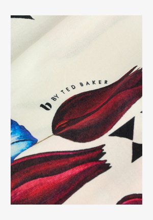 Zīda šalle ar ziedu rakstu, kurā ir sarkani un zili ziedi uz krēma fona, malā drukāta zīmola nosaukums "b by Ted Baker".