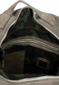 Interno di una borsa in tela grigia con un rivestimento a motivo camouflage, dotato di una tasca con cerniera e metalleria argentata.