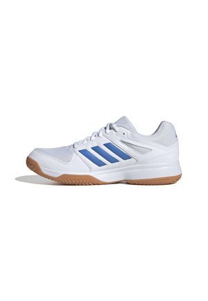 Baskets blanches de sport avec des rayures bleues, dessus en maille, et semelle en caoutchouc naturel, vues de profil sur un fond blanc.