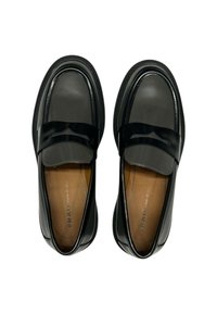 Mocassini neri in pelle con finitura liscia, punta arrotondata e un accento a striscia nera lucida. L'interno presenta una fodera in pelle marrone.