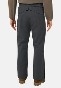 Harmaat housut suoralehtisellä mallilla, teksturoidulla kankaalla ja kahdella takataskulla. Yhdistetty ruskeisiin, paksupohjaisiin kenkiin.