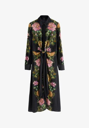 Čierne šaty s kvetinovou výšivkou, ktorá zobrazuje ružové, žlté a zelené kvety. Dlhé rukávy, golierový dizajn a detail viazania v pase.