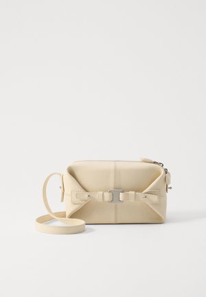 Beige leather crossbody bag with a rectangular shape, featuring a central buckle detail, zip closure, and adjustable strap.