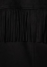 Zwarte suède stof met opvallende verticale franjes langs de bovenrand, een gladde textuur en nette stiksels langs de naad.